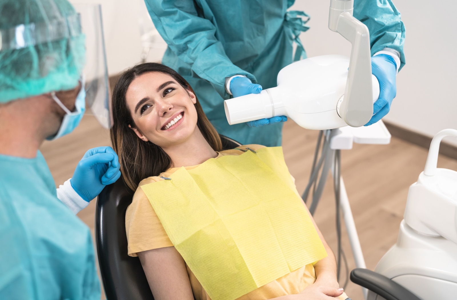 A young adult smiles at their dentist, calm and ready to have their teeth examined.
